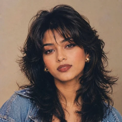 Young woman with a 1990s-inspired wolf cut hairstyle featuring feathered layers and curtain bangs