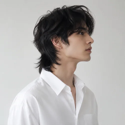 **Alt Text:**
Unique male model with an untapered wolf cut hairstyle wearing a white shirt in a right-side profile pose against a clean studio background.